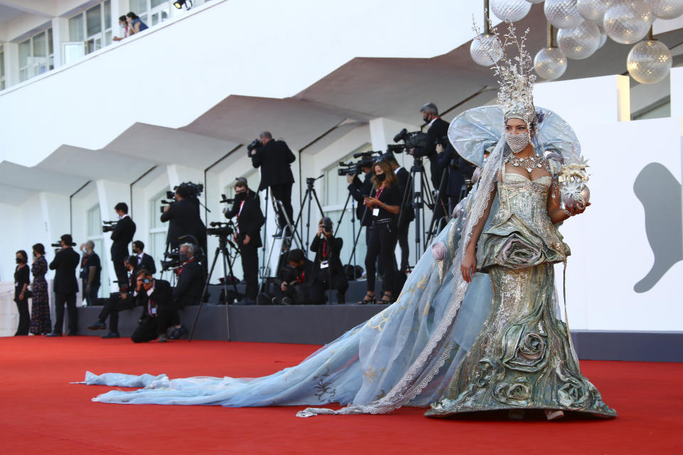 FILE - Actress Beatrice Schiaffino wears a mask as she arrives at the opening ceremony of the 77th edition of the Venice Film Festival in Venice, Italy, on Sept. 2, 2020. This year, three of the four major fall film festivals, including Venice, are going forward despite the pandemic. Those in Venice acknowledge it hasn’t been anywhere near the same. Masked moviegoers in set-apart seats. A barrier walls off the red carpet to discourage crowds of onlookers. Greetings are kiss-less. A little bit of the romance of movies has gone out. (Photo by Joel C Ryan/Invision/AP, File)