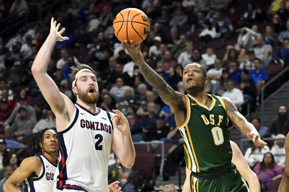 San Francisco guard Khalil Shabazz (0) shoots against Gonzaga forward Drew Timme (2) during the first half of an NCAA college basketball game in the semifinals of the West Coast Conference men's tournament Monday, March 6, 2023, in Las Vegas. (AP Photo/David Becker)