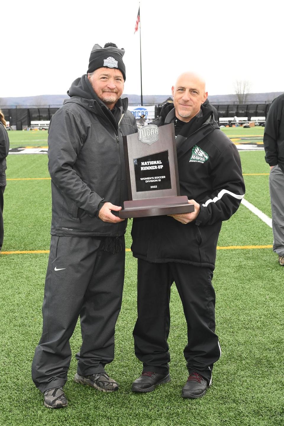 Herkimer College director of athletics Don Dutcher presents the runner-up trophy to Mohawk Valley Community College coach Jim Vitale Sunday at the NJCAA's Division III women's soccer championship match at Wehrum Stadium.