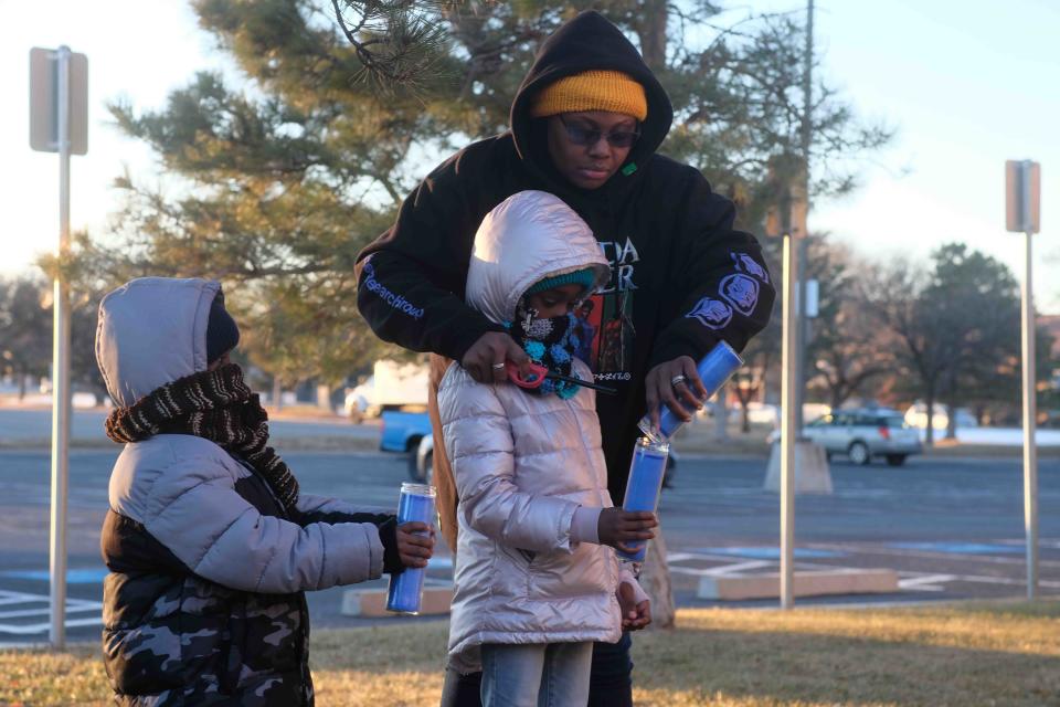 Diadria Robinson-Moore helps to the light candles of her two children Thursday at the Lights to End Human Trafficking Event in Amarillo.