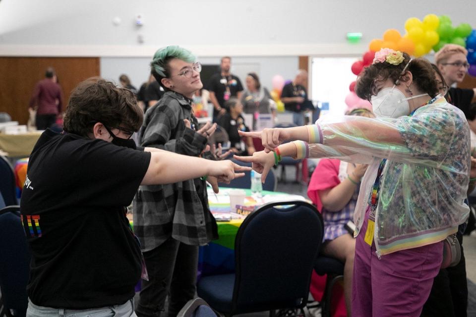 a group of teens pointing to each other in a dance sequence in a conference center