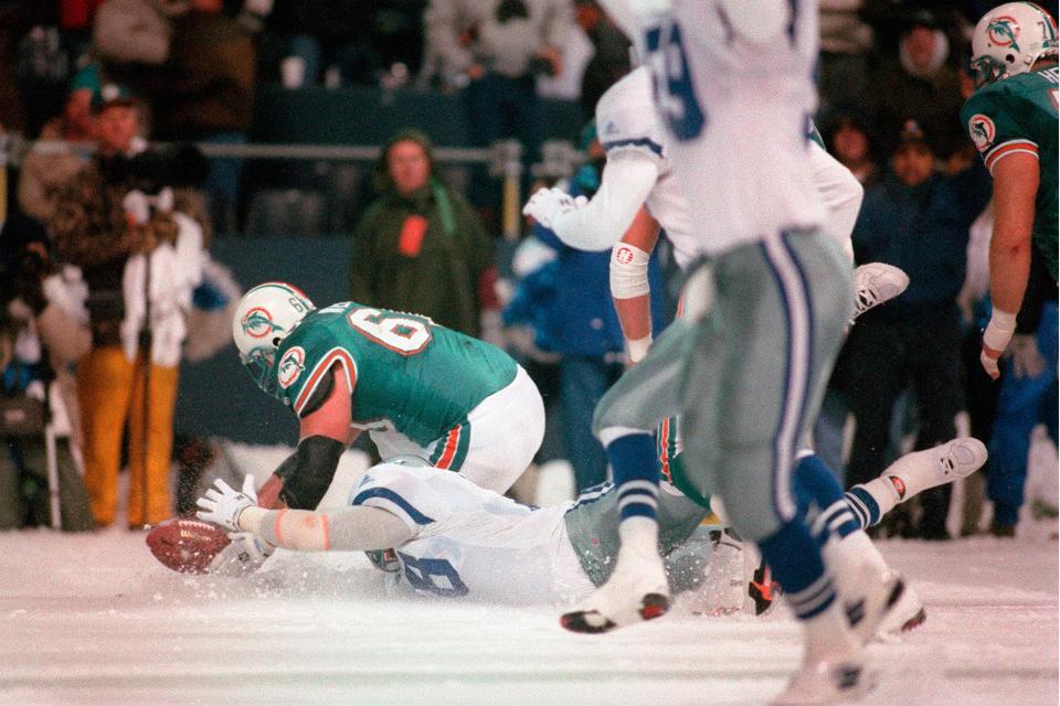 Cowboys' Leon Lett and Miami's Bert Weidner reach for a ball after Lett slid into the ball following a blocked field goal attempt on Nov. 25, 1993. After Lett touched the ball the Dolphins recovered and kicked again for a 16-14 win.