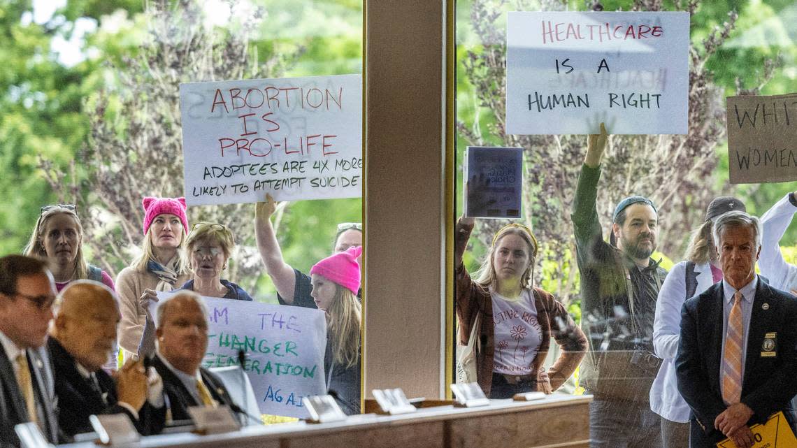 Demonstrators hold signs outside the legislature auditorium where a House Rules meeting was underway, May 3, 2023 at the Legislative Building. Republican state lawmakers announced their plan to limit abortion rights across the state.