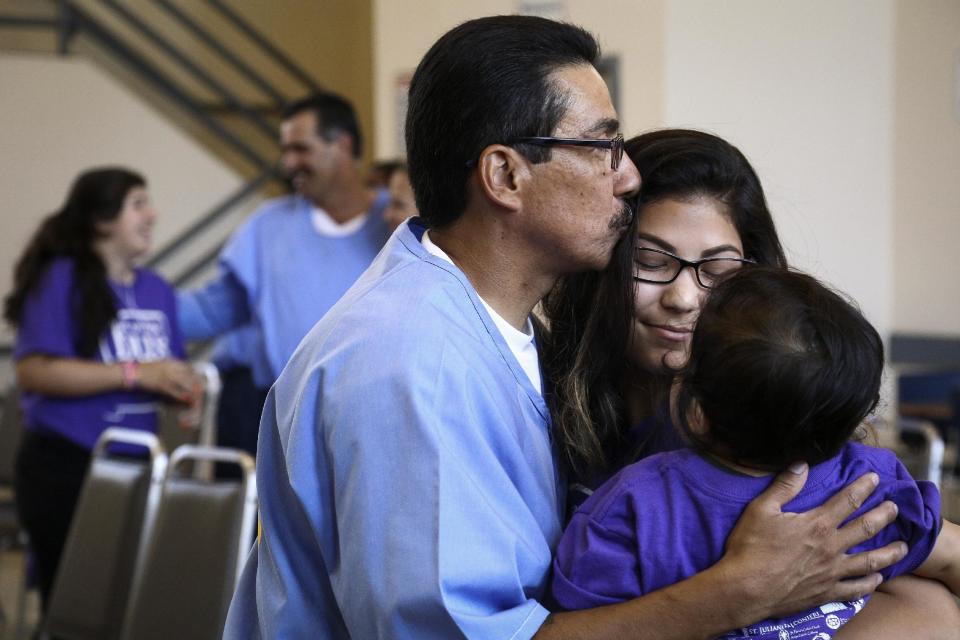 Manuel Zarate hugs his daughter and grandson at the end of a "Get On the Bus" visiting day to Folsom State Prison