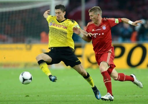 Bayern Munich's midfielder Bastian Schweinsteiger (R) fights for the ball with Dortmund's striker Robert Lewandowski during the German cup final football match at the Olympiastadion in Berlin. Dortmund beat Champions League finalists Bayern Munich 5-2 in Saturday's German Cup final to claim the first domestic double in their 103-year history