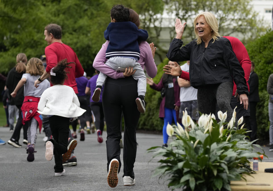 First lady Jill Biden high fives runners during the Joining Forces Military Kids Workout on the South Lawn of the White House in Washington, Saturday, April 29, 2023. The event is in honor of the Month of the Military Child. (AP Photo/Carolyn Kaster)