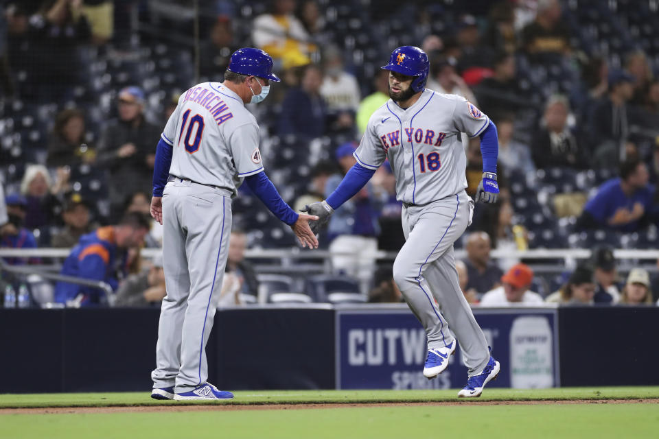 New York Mets' Jose Peraza (18) slaps hands with third base coach Gary Disarcina (10) as he rounds third base after hitting a solo home run during the fifth inning of the team's baseball game against the San Diego Padres on Saturday, June 5, 2021, in San Diego. (AP Photo/Derrick Tuskan)