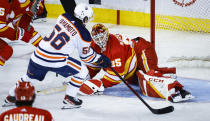 Edmonton Oilers right wing Kailer Yamamoto, left, scores on Calgary Flames goalie Jacob Markstrom during the third period of Game 1 of an NHL hockey second-round playoff series Wednesday, May 18, 2022, in Calgary, Alberta. (Jeff McIntosh/The Canadian Press via AP)