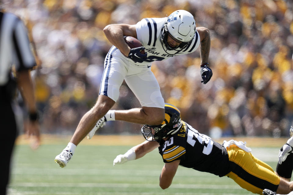Utah State wide receiver Colby Bowman (8) is tackled by Iowa defensive back Quinn Schulte (30) during the first half of an NCAA college football game, Saturday, Sept. 2, 2023, in Iowa City, Iowa. (AP Photo/Charlie Neibergall)