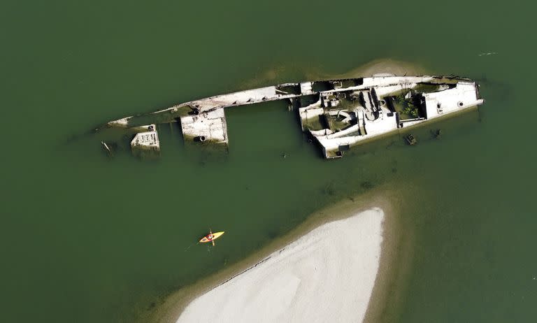 Un kayakista rema junto a los restos de un buque de guerra alemán de la Segunda Guerra Mundial en el río Danubio cerca de Prahovo, Serbia