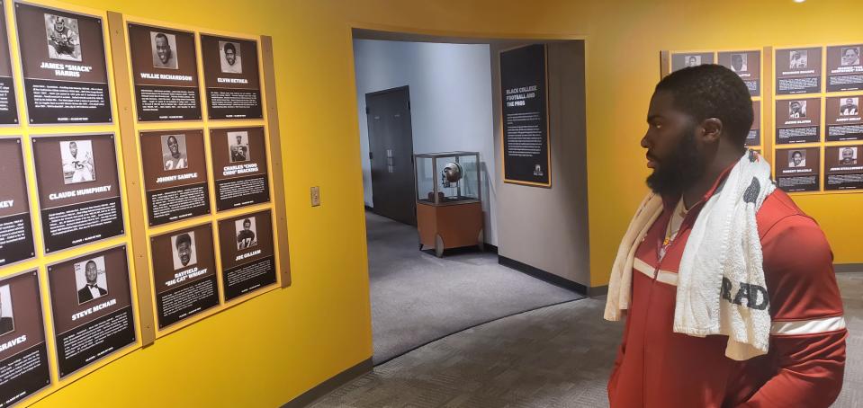 Virginia Union running back Jada Byers stares at the wall filled with members of the Black College Football Hall of Fame in an exhibit at the Pro Football Hall of Fame Museum, Saturday.