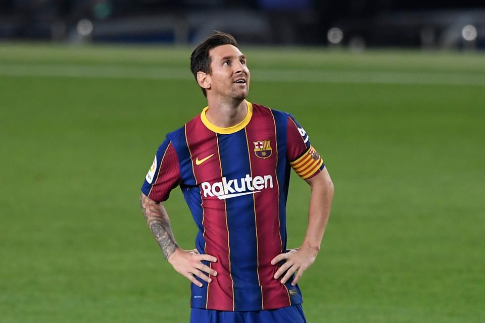 Lionel Messi looks up with his hands on his hips.
