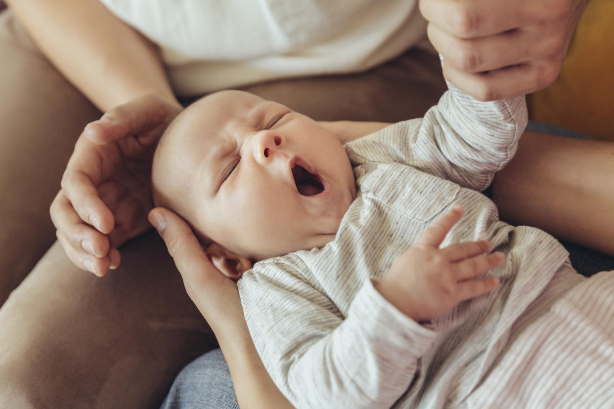 Midwife and mother checking on sleepy newborn baby