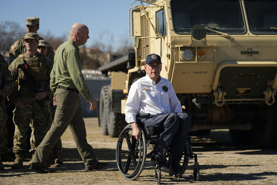 Texas Gov. Greg Abbott, right, and Montana Gov. Greg Gianforte, left, walk past members of the National Guard as they arrive with fellow governors for a news conference along the Rio Grande to discuss Operation Lone Star and border concerns, Sunday, Feb. 4, 2024, in Eagle Pass, Texas. Abbott returned to the Eagle Pass border to highlight his escalating attempts to curb illegal crossings on the U.S.-Mexico border. (AP Photo/Eric Gay)
