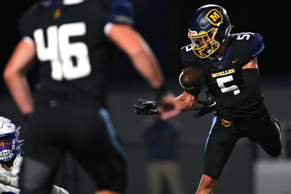 Moeller Crusaders defensive back Drew Robinson (5) intercepts a pass in the second half of a high school football game between the St. Xavier Bombers and the Moeller Crusaders, Friday, Sept. 15, 2023, at Welcome Stadium in Dayton, Ohio.