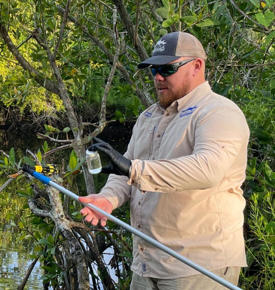 Calusa Waterkeeper Codty Pierce with a sample of Caloosahatchee water to be analyzed to determine if it was tainted with fecal bacteria. Spoiler: It was.