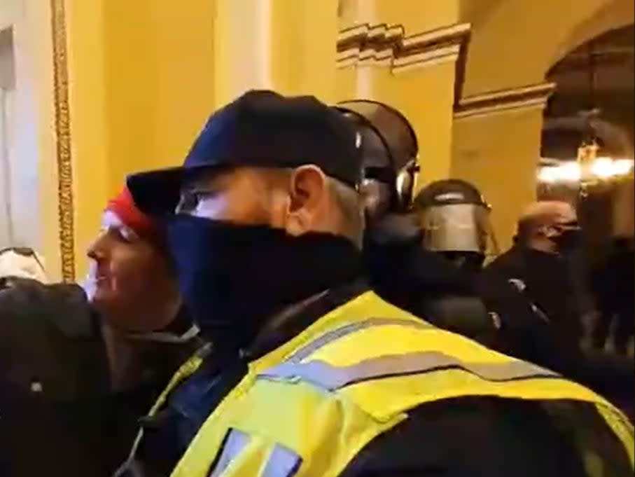 <p>Footage revealed a member of the United States Capitol Police posing for a selfie with a rioter</p> (Twitter/ Timothy Burke)
