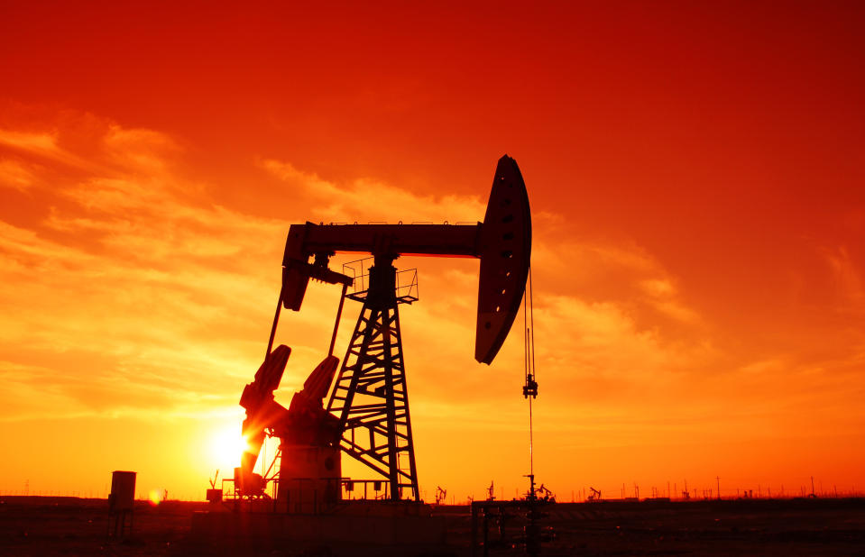 Oil rig silhouette with an orange sunrise in the background