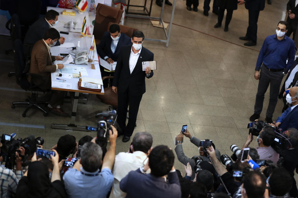 Revolutionary Guard Gen. Saeed Mohammad, who once headed the the paramilitary force's Khatam al-Anbiya Construction Headquarters, shows his identification document while registering his name as a candidate for the June 18, presidential elections at elections headquarters of the Interior Ministry in Tehran, Iran, Tuesday, May 11, 2021. Iran opened registration Tuesday for potential candidates in the country's June presidential election, kicking off the race as uncertainty looms over Tehran's tattered nuclear deal with world powers and tensions remain high with the West. (AP Photo/Vahid Salemi)