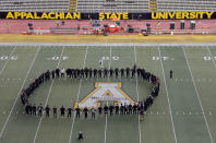 <p>Appalachian State football players hold hands at mid-field before an NCAA college football game against Miami in Boone, N.C., Sept. 17, 2016. (Photo: Chuck BurtonAP) </p>