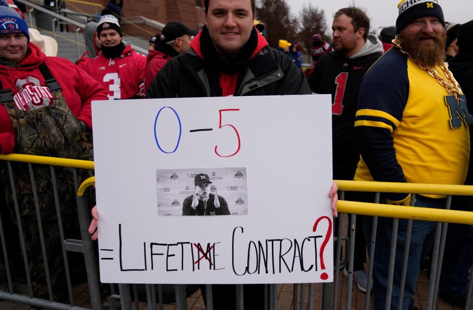 Ohio State fan holds a Jim Harbaugh sign prior to the game against the Michigan Wolverines at Michigan Stadium in Ann Arbor on Saturday, Nov. 27, 2021.