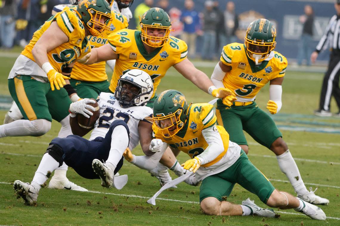 North Dakota State safety Dawson Weber (2) stops Montana State running back Isaiah Ifanse (22) during the first half of the FCS Championship NCAA college football game in Frisco, Texas, Saturday, Jan. 8, 2022. Helping to defend in the player are defensive end Brayden Thomas (98), defensive tackle Costner Ching (94) and linebacker Jasir Cox (3). (AP Photo/Michael Ainsworth)