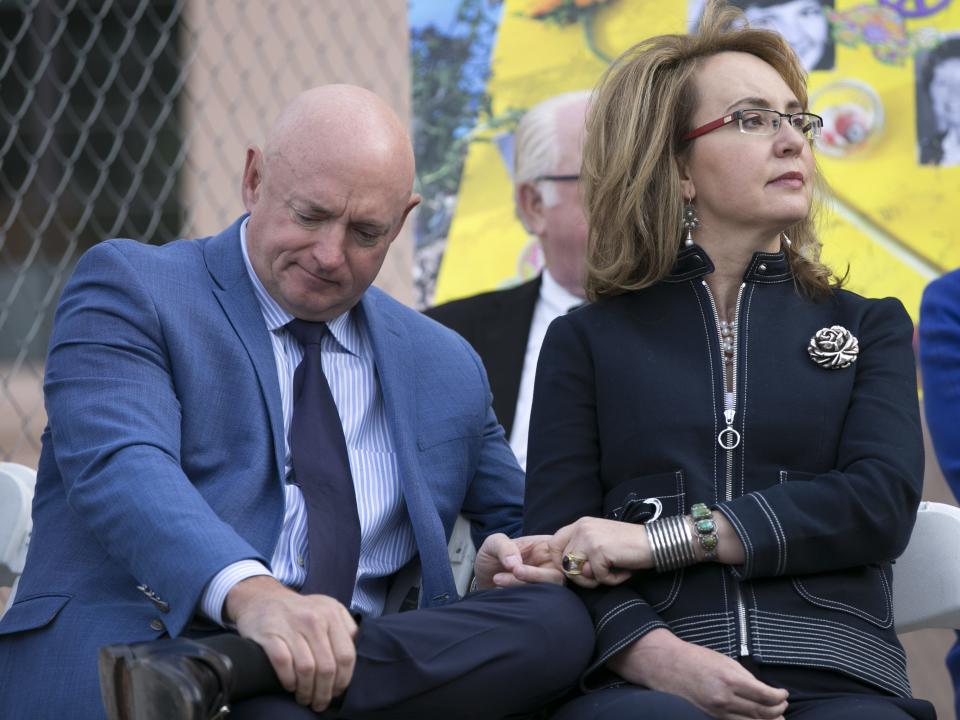 Former U.S. Rep. Gabrielle Giffords holds the hand of her husband, Mark Kelly, during the memorial dedication for Tucson's January 8th Memorial at El Presidio Park in Tucson on Monday, Jan. 8, 2018. The dedication was held on the seven-year anniversary of the Tucson mass shooting.