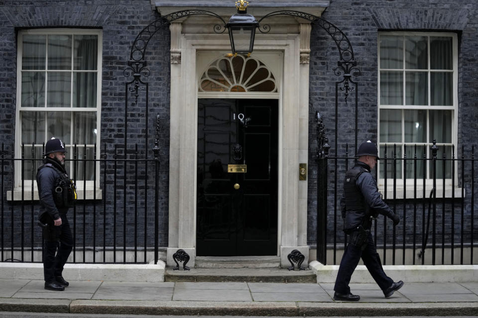 Police officers walk past 10 Downing Street in London, Tuesday, Jan. 25, 2022. London police say they are now investigating Downing Street parties during lockdown. Metropolitan Police Commissioner Cressida Dick revealed an investigation was underway in a statement before the London Assembly on Tuesday. Dick said Scotland Yard is now investigating "a number of events" at Downing Street. (AP Photo/Kirsty Wigglesworth)
