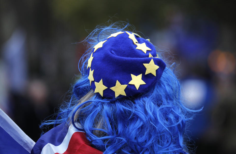 A pro-European demonstrator wears a Union Jack flag and a hat with the EU colors during a protest opposite the Houses of Parliament in London, Tuesday, Jan. 15, 2019. Britain's Prime Minister Theresa May is struggling to win support for her Brexit deal in Parliament. Lawmakers are due to vote on the agreement Tuesday, and all signs suggest they will reject it, adding uncertainty to Brexit less than three months before Britain is due to leave the EU on March 29. (AP Photo/Frank Augstein)