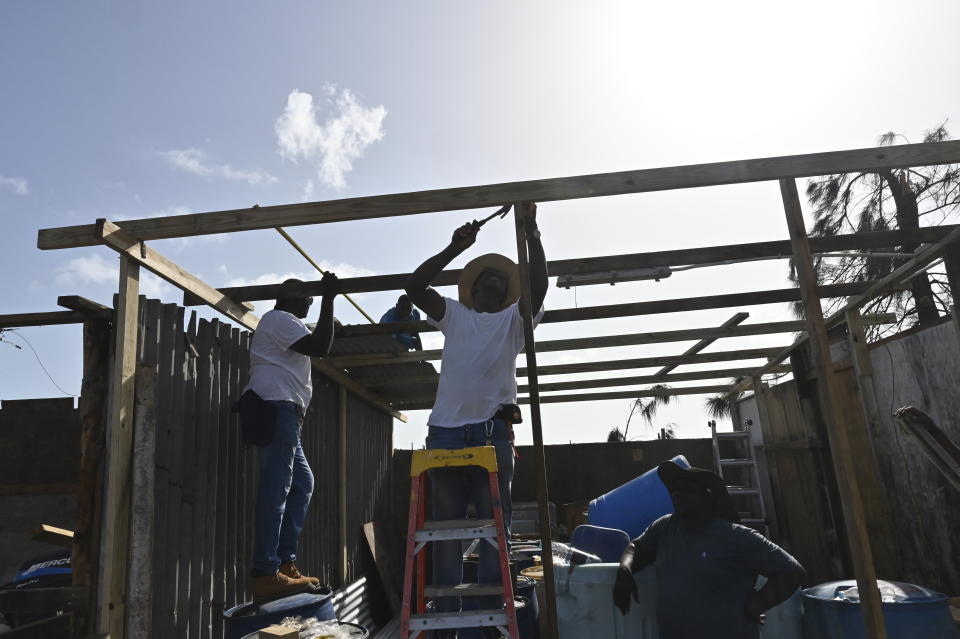 Several people work to repair a house destroyed by Hurricane Beryl in the fishing settlement of Rocky Point, Clarendon, Jamaica, Thursday, July 4, 2024. (AP Photo/Collin Reid)