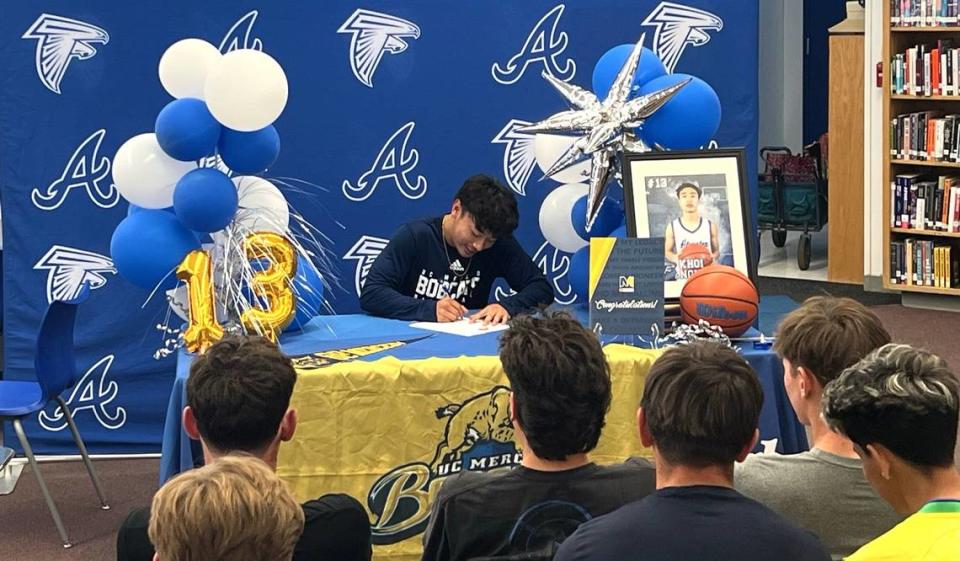 Atwater High senior Khoi Nguyen signs his national letter of intent to play basketball at UC Merced during a ceremony in the Atwater High library on Wednesday, May 22, 2024.