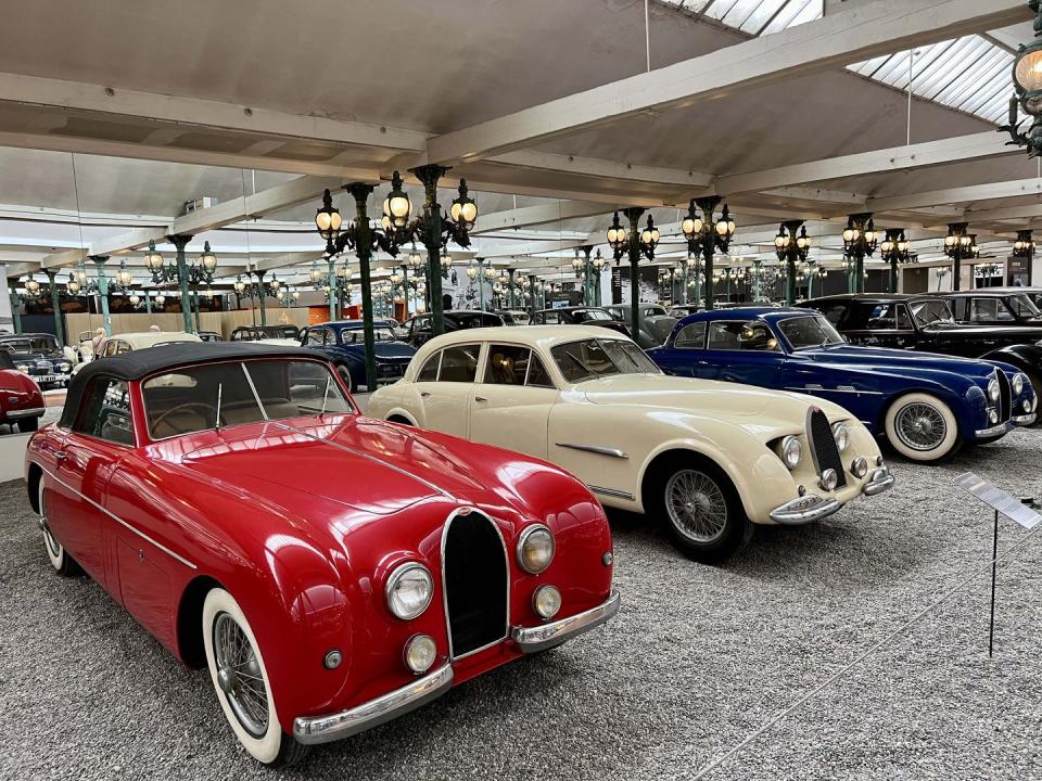 a group of cars parked in a room with other cars