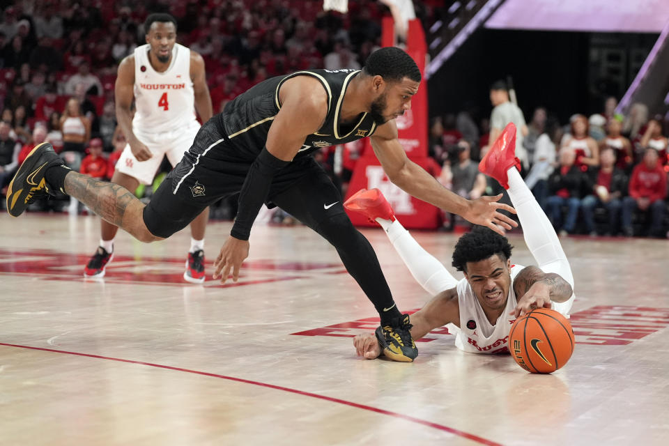 Central Florida's Darius Johnson, left, steps on the hand of Houston's Ramon Walker Jr. while chasing a loose ball during the second half of an NCAA college basketball game Saturday, Jan. 20, 2024, in Houston. (AP Photo/David J. Phillip)