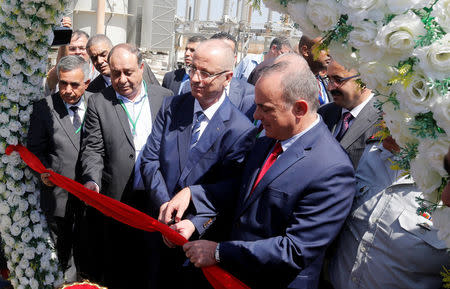 Palestinian Prime Minister Rami Hamdallah and Israeli Energy Minister Yuval Steinitz cut the ribbon during the inauguration of an electrical substation near the West Bank city of Jenin July 10, 2017. REUTERS/Abed Omar Qusini