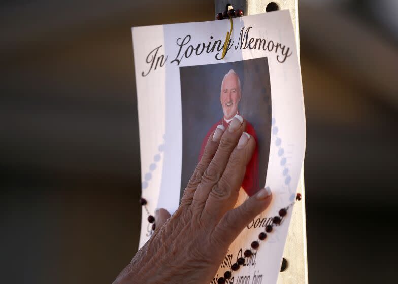 HACIENDA HEIGHTS, CALIF. - FEB. 19, 2023. A woman touches a picture of Roman Catolic Bishop David O'Connell, who died from a gunshot wound at his Hacienda Heights home on Saturday, Dec. 18, 2023. Police are investigating the case as a homicide. (Luis Sinco / Los Angeles Times)