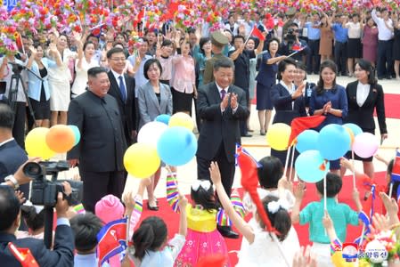 North Korean leader Kim Jong Un welcomes Chinese President Xi Jinping at the Pyongyang International Airport in Pyongyang