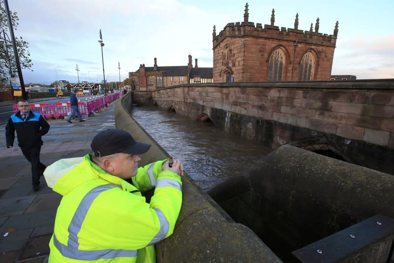 Man looks at Chantry Bridge, as it sits partially in floodwater in Rotherham, near Sheffield