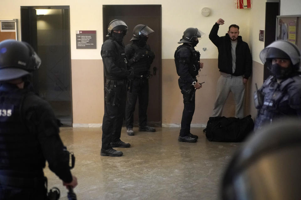 Rap singer Pablo Hasél reacts next to police officers before being detained at the University of Lleida, Spain, Tuesday, Feb. 16, 2021. A rapper in Spain and dozens of his supporters have locked themselves inside a university building in the artist's latest attempt to avoid a prison sentence for insulting the monarchy and praising terrorism. (AP Photo/Joan Mateu)