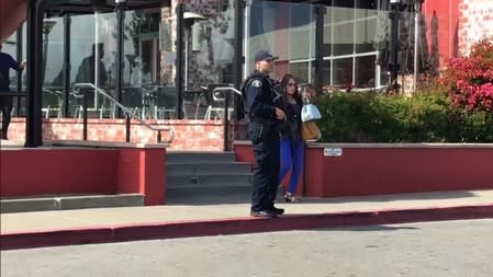 An armed police officer stands guard near the scene of a shooting at the Tanforan Mall shopping center in the San Francisco suburb of San Bruno