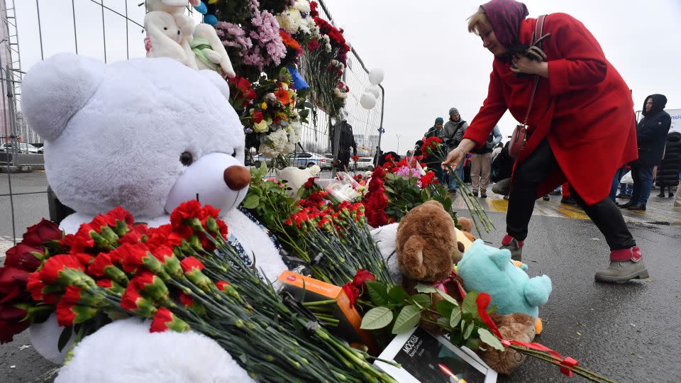 A woman lays flowers at a makeshift memorial on Saturday. - Olga Maltseva/AFP/Getty Images