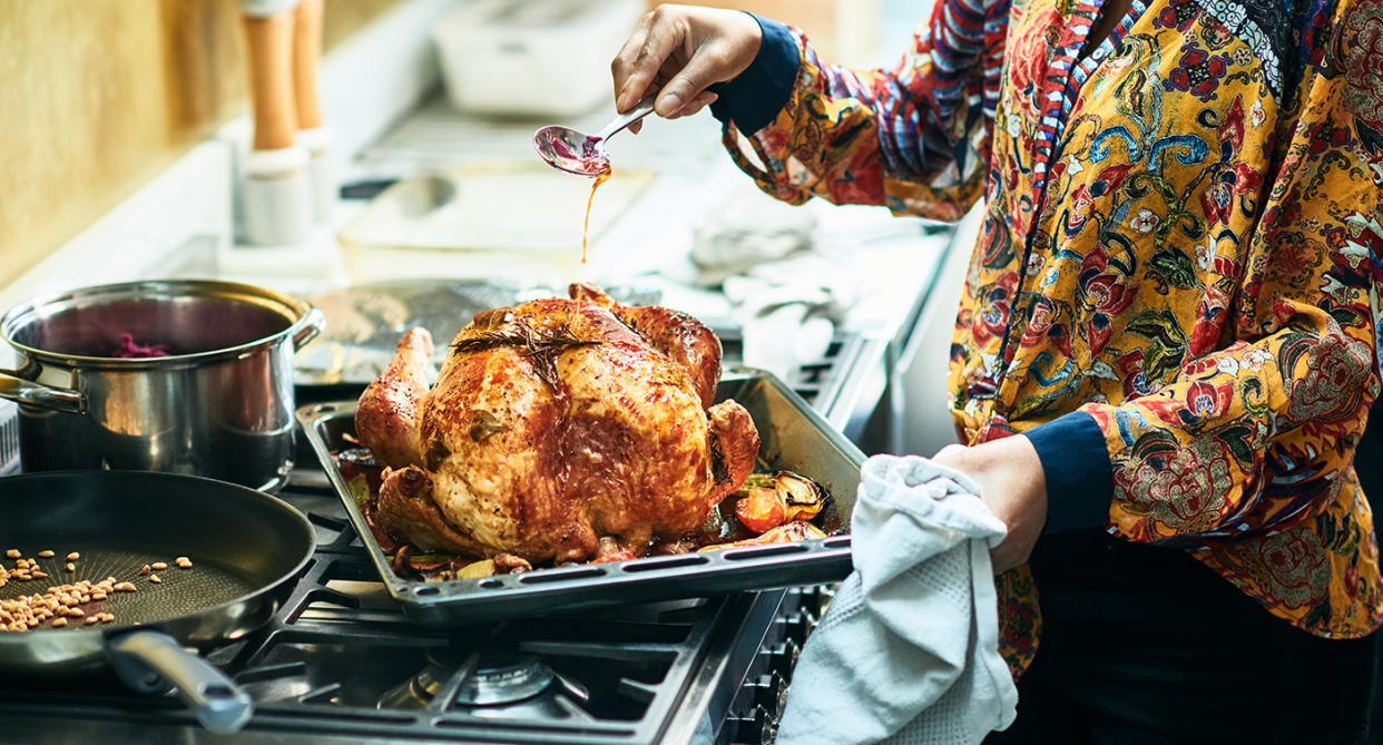 Woman seasoning Christmas turkey. (Getty Images)