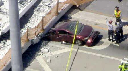 Emergency crews look for victims at the scene of a collapsed pedestrian bridge at Florida International University in Miami, Florida, U.S., March 15, 2018 in this still image from video. Courtesy of WTVJ-NBCMiami.com/Handout via REUTERS