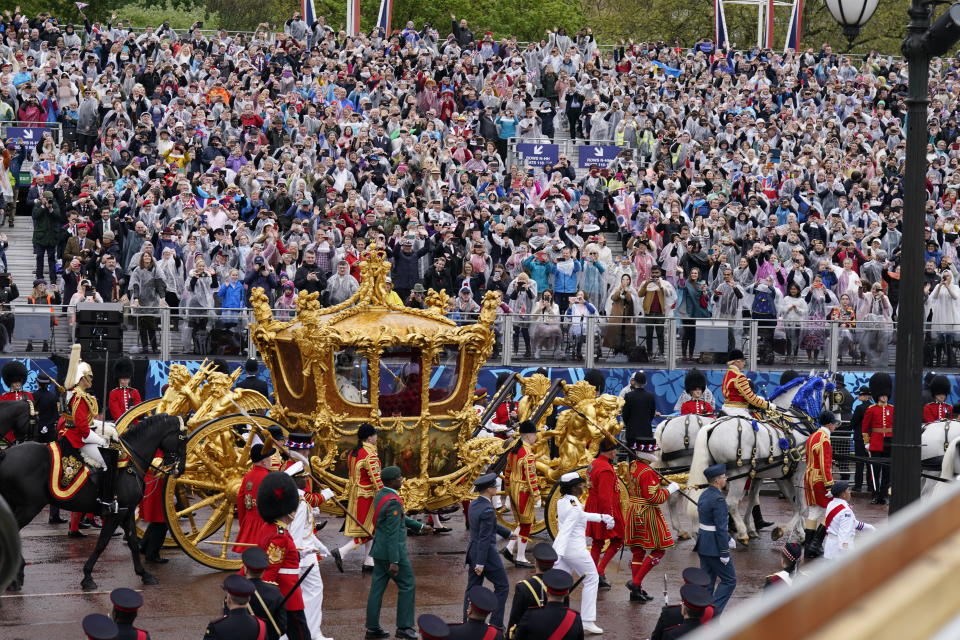 King Charles III and Queen Camilla are carried in the Gold State Coach, pulled by eight Windsor Greys, in The Coronation Procession as they return along The Mall to Buckingham Palace, London, following their coronation ceremony.