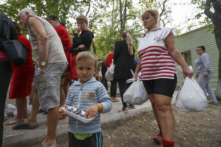 Ukrainian refugees from the Donetsk region receive food as humanitarian aid on the outskirts of the southern coastal town of Mariupol September 10, 2014. REUTERS/Vasily Fedosenko