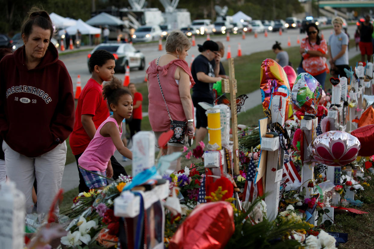 People grieve in front of crosses and Stars of David placed in front of the fence of the Marjory Stoneman Douglas High School to commemorate the victims of the mass shooting, in Parkland, Florida, U.S., Feb. 21, 2018 (Photo: Carlos Garcia Rawlins / Reuters)
