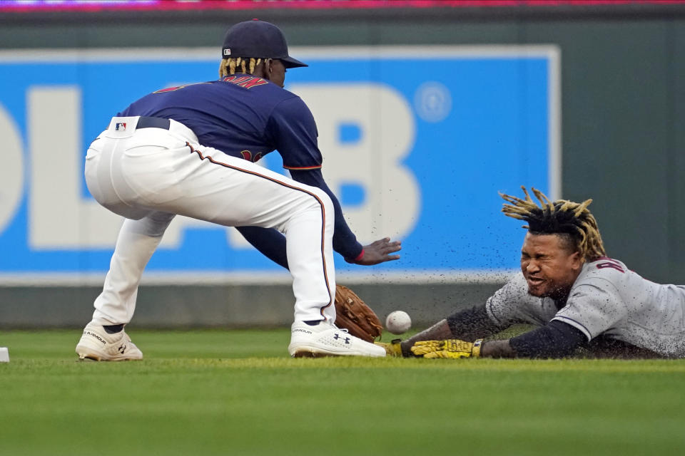 Cleveland Indians' Jose Ramirez, right, tries to stretch a single into a double as Minnesota Twins shortstop Nick Gordon reaches for the ball and tags Ramirez out during the first inning of a baseball game Wednesday, Sept. 15, 2021, in Minneapolis. (AP Photo/Jim Mone)