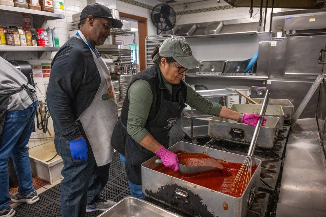 Chef Edwin Burton of Loaves & Fishes, left, looks on as volunteer Ja’net Blea cooks on one of the stoves that is working on Wednesday, Nov. 15. The Sacramento nonprofit dedicated to feeding the hungry and sheltering the homeless is asking for new stoves.