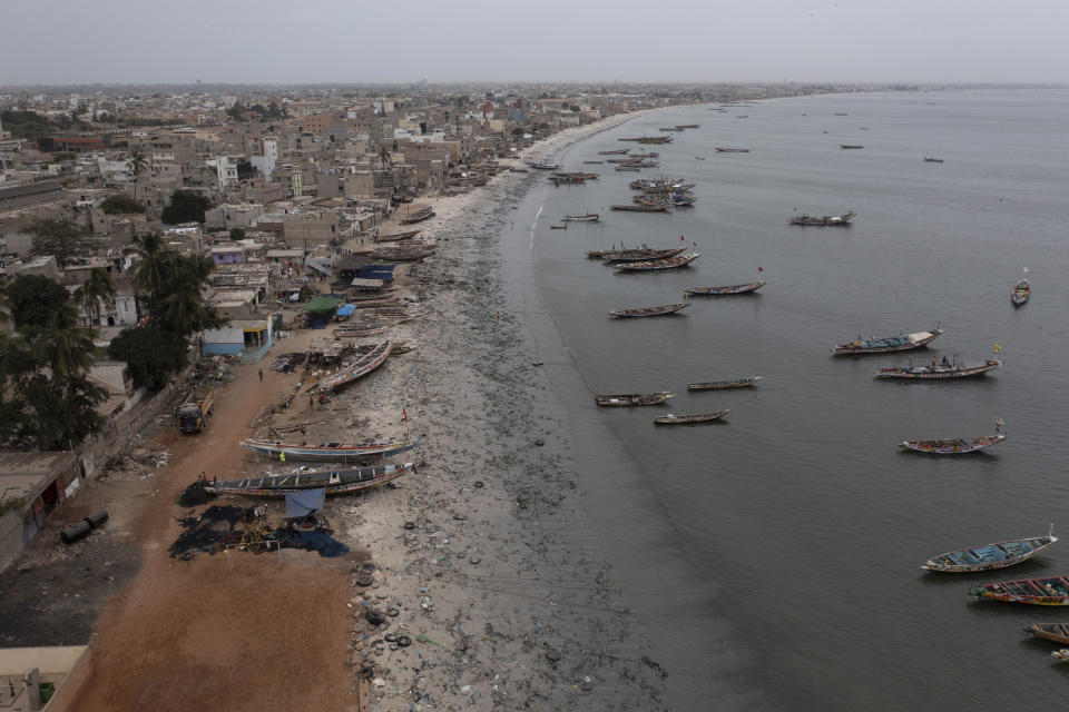 Traditional boats, known as pirogues, are docked at the Yarakh Beach littered by trash and plastics in Dakar, Senegal, Tuesday, Nov. 8, 2022. In 2020, Senegal passed a law that banned some plastic products. But if the mountains of plastic garbage on this beach are any indication, the country is struggling with enforcement. (AP Photo/Leo Correa)