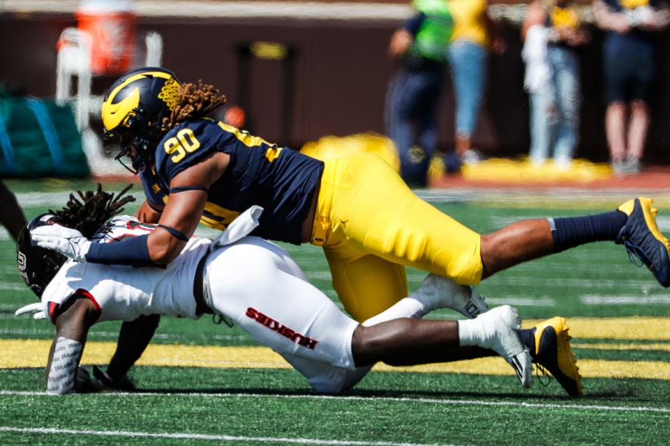Michigan defensive end Mike Morris (90) tackles Northern Illinois running back Erin Collins (21) during the second half at Michigan Stadium in Ann Arbor on Saturday, Sept. 18, 2021.