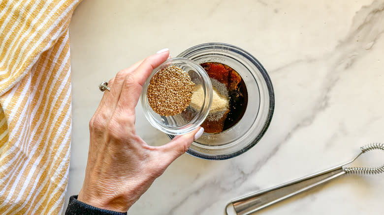 adding sesame seeds to bowl